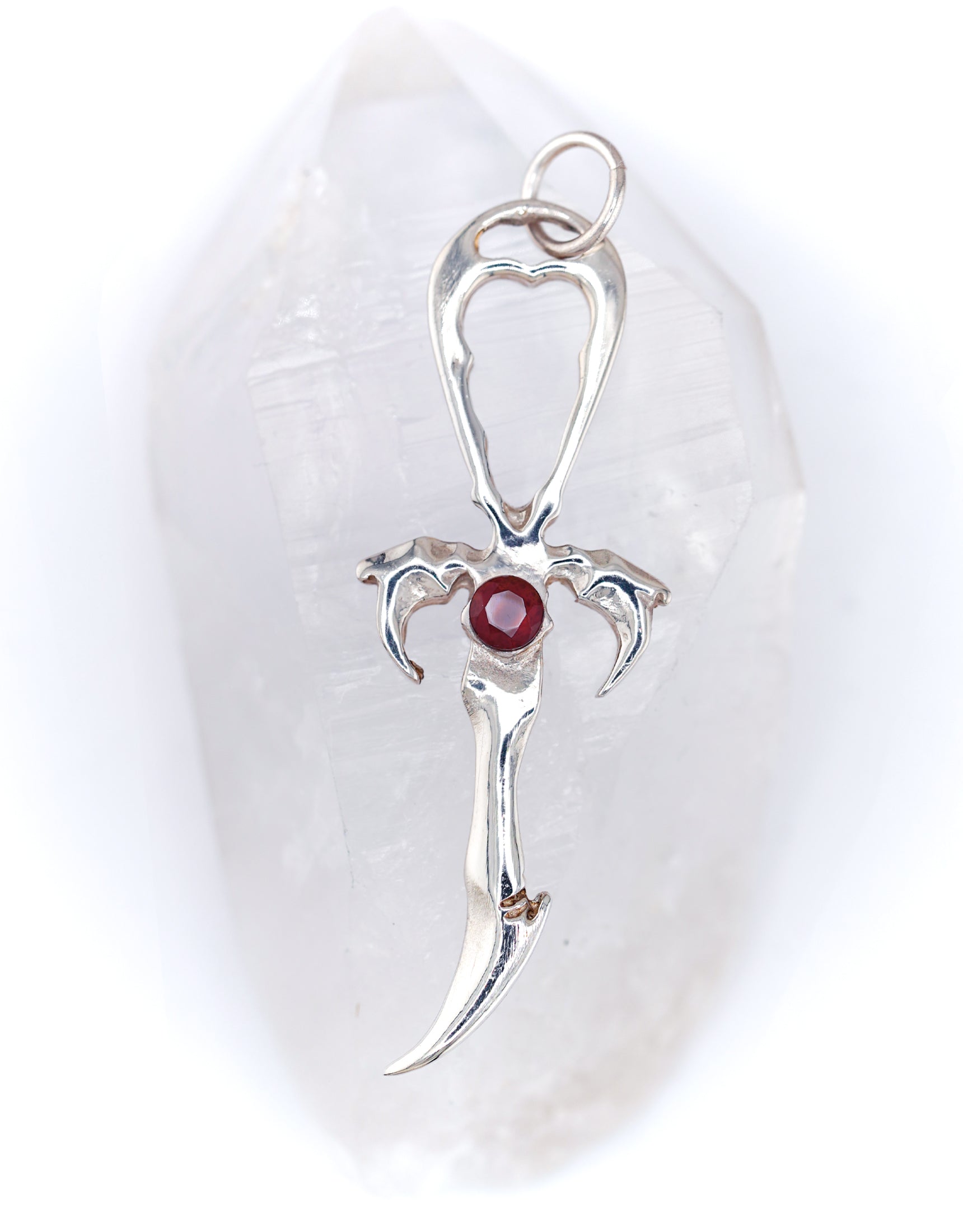 A silver Vampire Legacy Ankh pendant with a round, red garnet gem at its center, displayed against a white background.